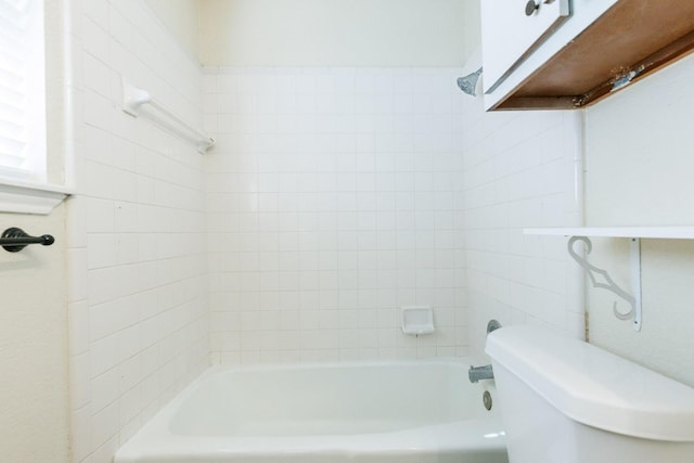 bathroom featuring tiled shower / bath combo and toilet