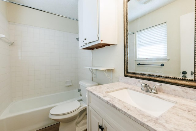 full bathroom with vanity, tiled shower / bath combo, and toilet