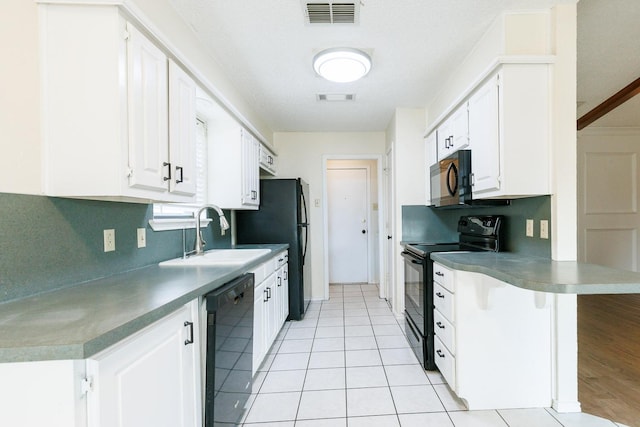 kitchen with sink, a breakfast bar area, white cabinetry, kitchen peninsula, and black appliances