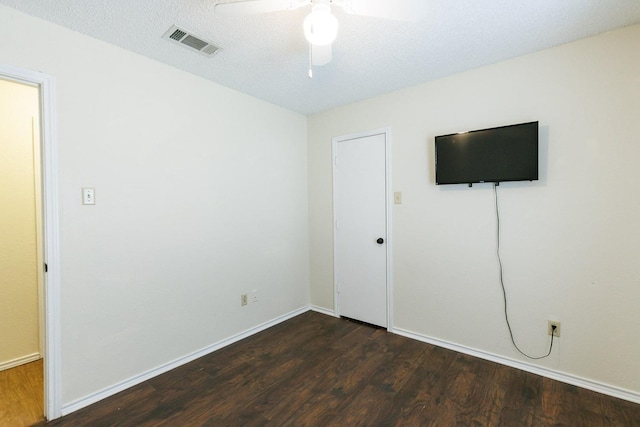 unfurnished bedroom with dark hardwood / wood-style flooring, ceiling fan, and a textured ceiling