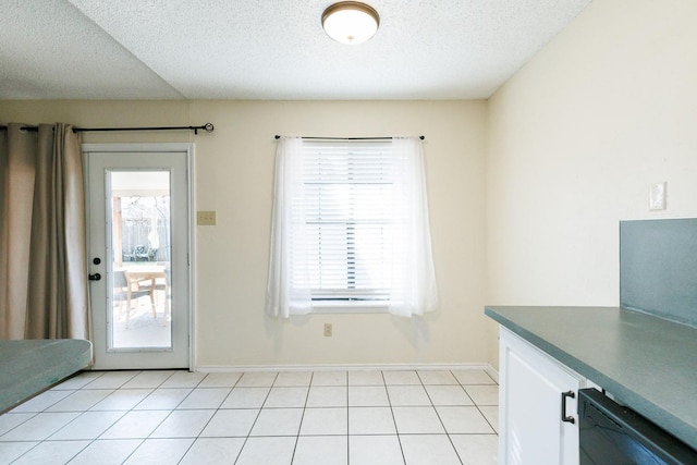 doorway with light tile patterned floors and a textured ceiling