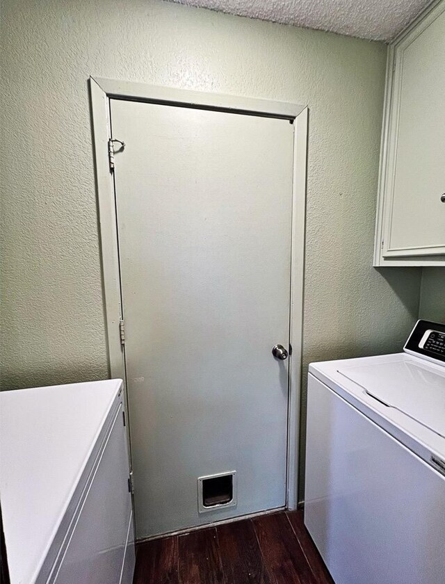 laundry area with washer / clothes dryer, dark wood-type flooring, a textured ceiling, and cabinets