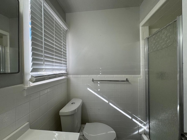 bathroom with walk in shower, vanity, toilet, and tile walls