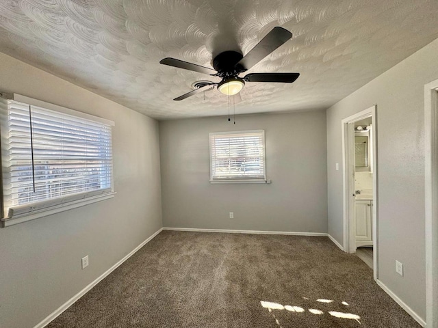 unfurnished bedroom featuring ceiling fan, carpet flooring, connected bathroom, and a textured ceiling