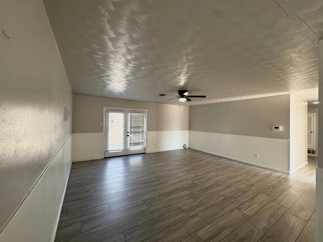 unfurnished room with hardwood / wood-style floors, a textured ceiling, and french doors