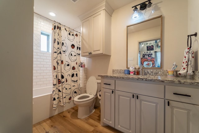 full bathroom featuring vanity, hardwood / wood-style flooring, toilet, and shower / bath combo with shower curtain