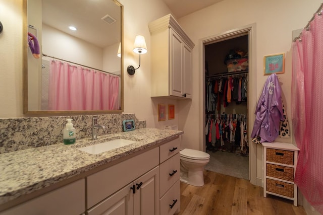 bathroom featuring vanity, hardwood / wood-style floors, and toilet