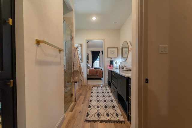 bathroom featuring walk in shower, vanity, and hardwood / wood-style floors