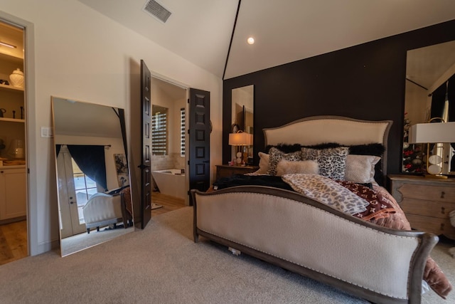 bedroom featuring lofted ceiling, ensuite bathroom, and carpet