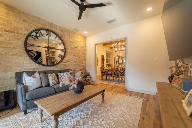 living room featuring hardwood / wood-style floors and ceiling fan with notable chandelier