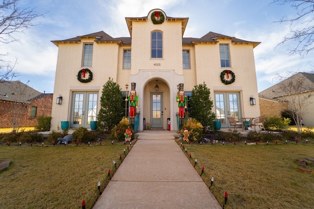 view of front of house with a front yard and french doors