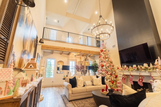 living room with high vaulted ceiling, beam ceiling, hardwood / wood-style floors, and a notable chandelier