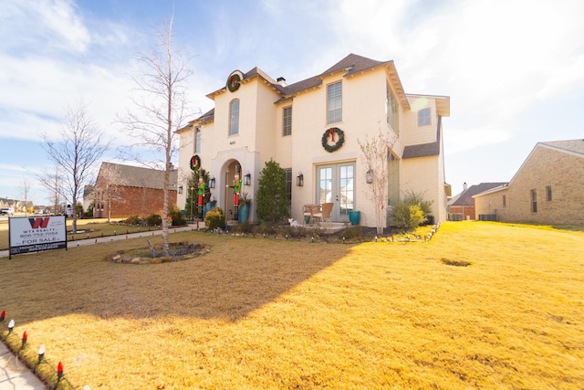 view of front facade featuring french doors and a front lawn