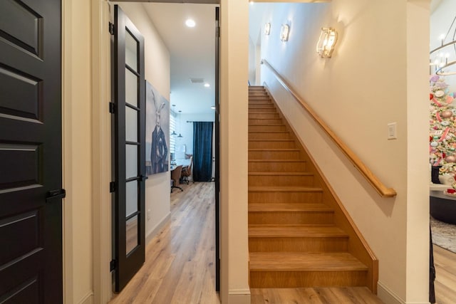 staircase with hardwood / wood-style floors