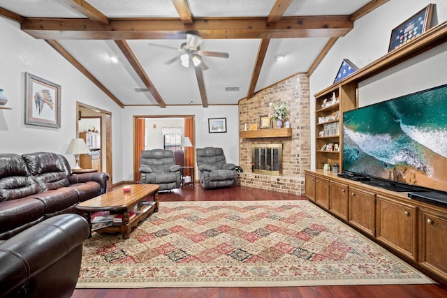 living room featuring lofted ceiling with beams, built in features, ceiling fan, a fireplace, and hardwood / wood-style floors