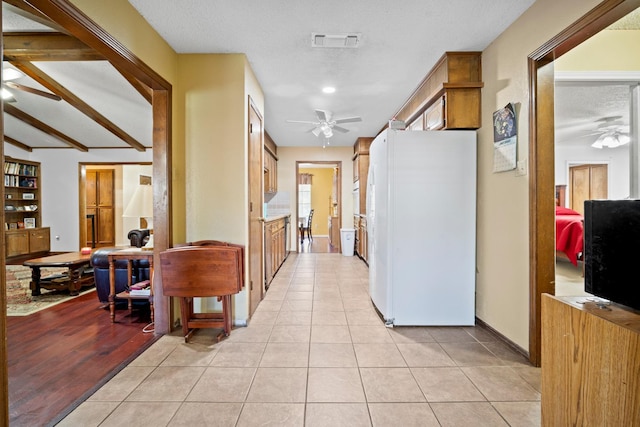 corridor with light tile patterned floors and a textured ceiling