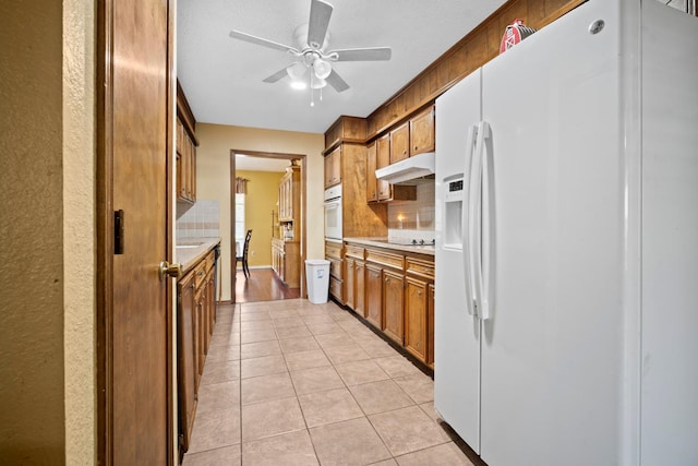 kitchen with ceiling fan, white appliances, decorative backsplash, and light tile patterned floors