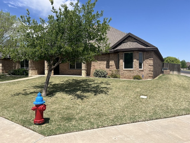 view of front of home featuring a front yard and brick siding