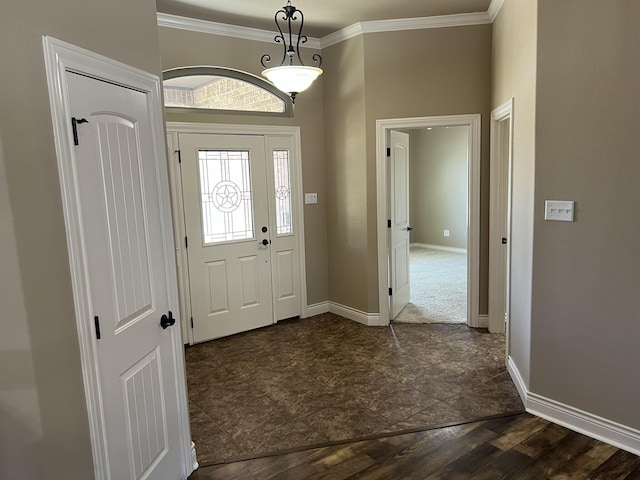 entrance foyer featuring crown molding, stone finish floor, and baseboards