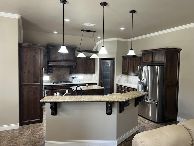 kitchen with crown molding, visible vents, dark brown cabinets, stainless steel refrigerator with ice dispenser, and an island with sink