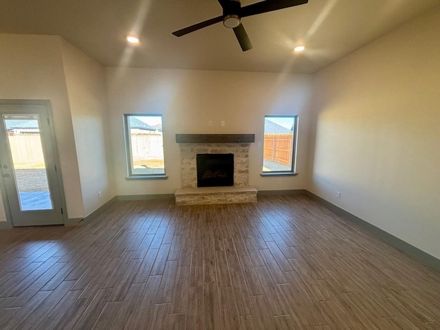 unfurnished living room with dark hardwood / wood-style flooring and ceiling fan