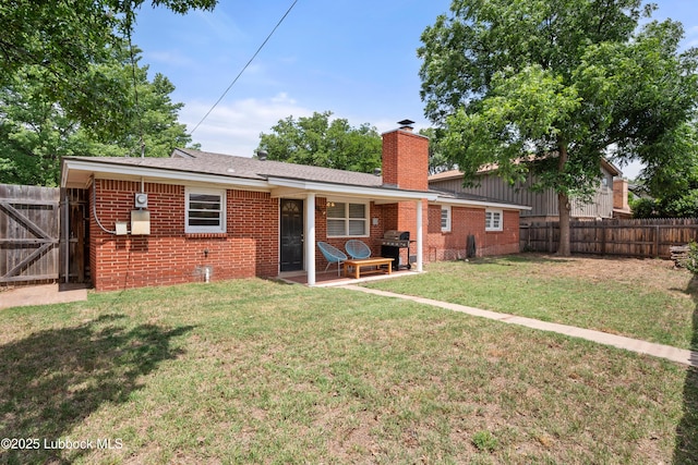 6405 Joliet Ave, Lubbock, TX 79413 - back of property featuring brick siding, a fenced backyard, a chimney, and a patio