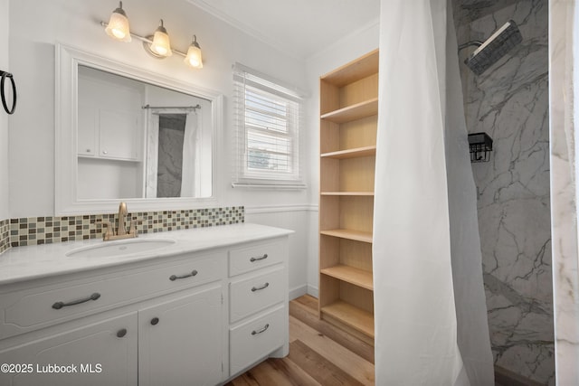 6405 Joliet Ave, Lubbock, TX 79413 - bathroom featuring vanity, ornamental molding, wood finished floors, decorative backsplash, and a marble finish shower