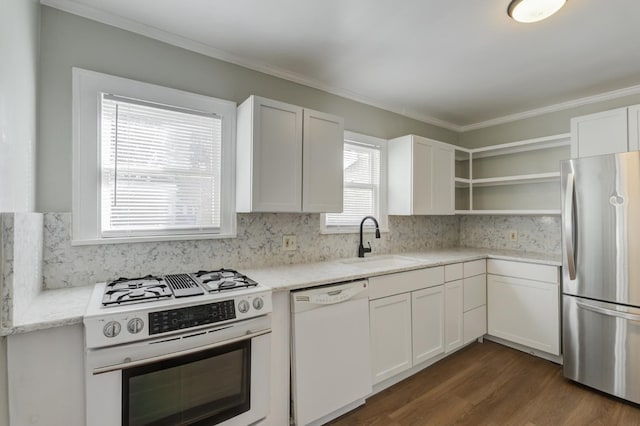 kitchen with white cabinetry, stainless steel appliances, light stone countertops, and sink