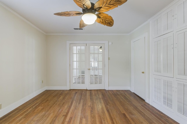 empty room with dark wood-type flooring, ornamental molding, french doors, and ceiling fan