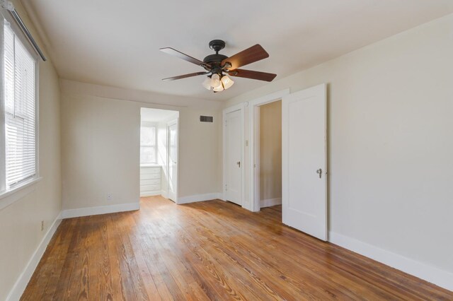 unfurnished bedroom featuring ensuite bath, light hardwood / wood-style flooring, and ceiling fan