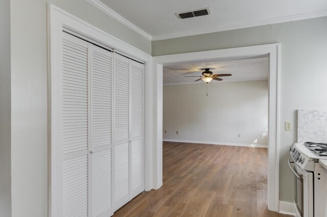 hallway with hardwood / wood-style flooring and ornamental molding