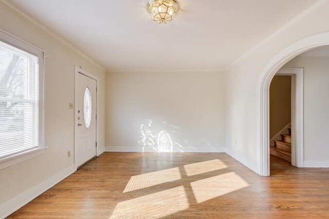 foyer with crown molding and light hardwood / wood-style flooring