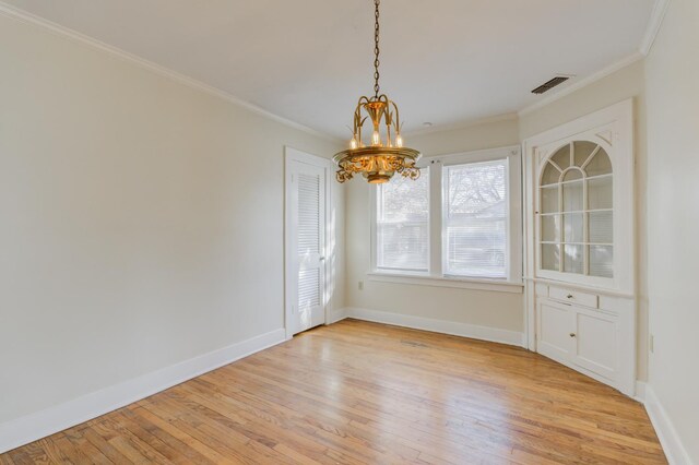 unfurnished dining area featuring ornamental molding, a chandelier, and light hardwood / wood-style floors