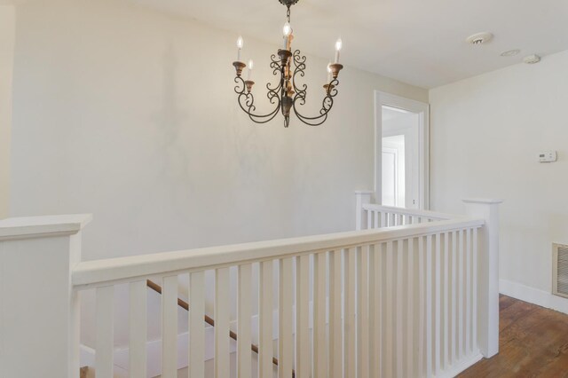 corridor with an inviting chandelier and hardwood / wood-style flooring