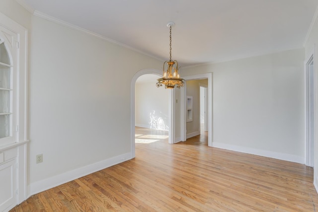 unfurnished room featuring crown molding, light hardwood / wood-style flooring, and a chandelier