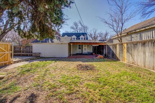 rear view of property with a patio and a lawn