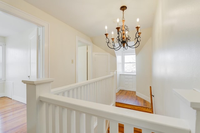 corridor featuring a notable chandelier and light hardwood / wood-style flooring