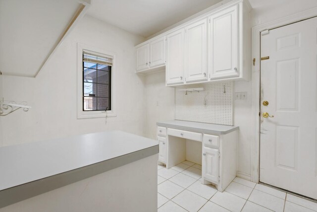 kitchen featuring light tile patterned flooring, tasteful backsplash, and white cabinets