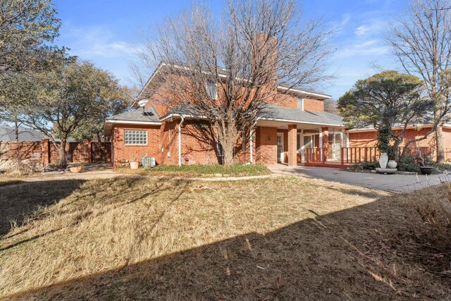 view of front of home featuring a front yard and central air condition unit