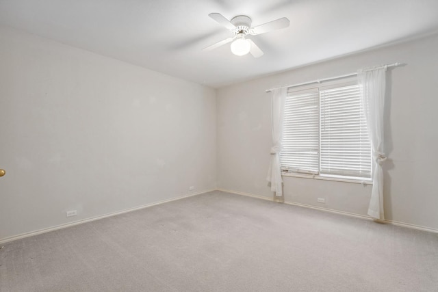 spare room featuring light colored carpet and ceiling fan