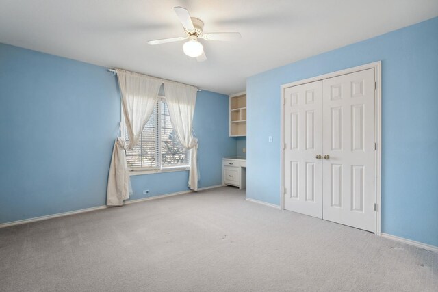 unfurnished bedroom featuring ceiling fan, light colored carpet, and a closet