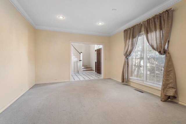 carpeted spare room featuring crown molding