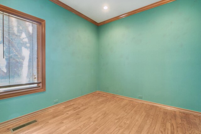 unfurnished room featuring hardwood / wood-style flooring and ornamental molding