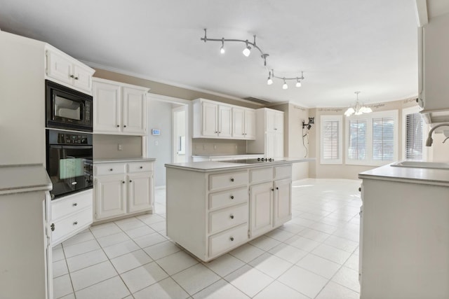 kitchen with pendant lighting, sink, white cabinetry, black appliances, and a kitchen island