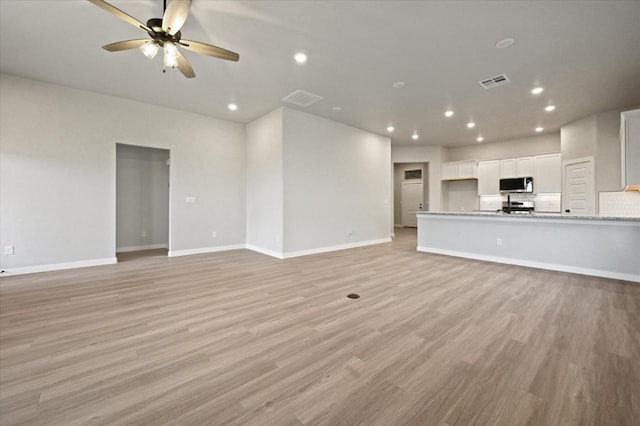 unfurnished living room featuring ceiling fan and light hardwood / wood-style floors