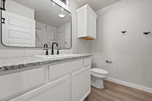 bathroom with walk in shower, vanity, toilet, and hardwood / wood-style floors