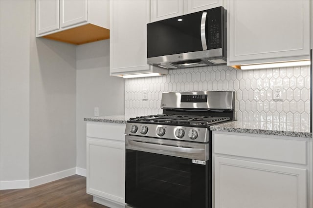 kitchen featuring light stone counters, appliances with stainless steel finishes, and white cabinets