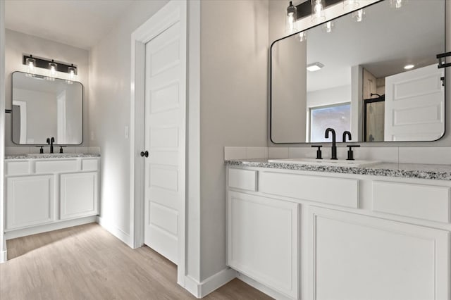 bathroom with vanity, hardwood / wood-style flooring, and a shower with shower door