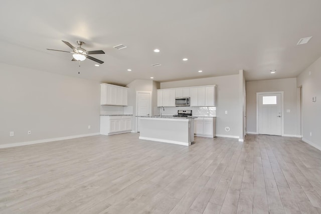 unfurnished living room with ceiling fan, sink, and light hardwood / wood-style flooring