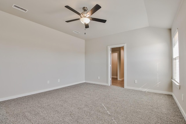 carpeted empty room featuring vaulted ceiling and ceiling fan